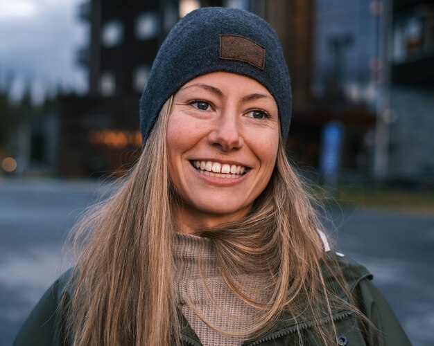 Portrait of a smiling blonde caucasian female in a coat and hat in winter