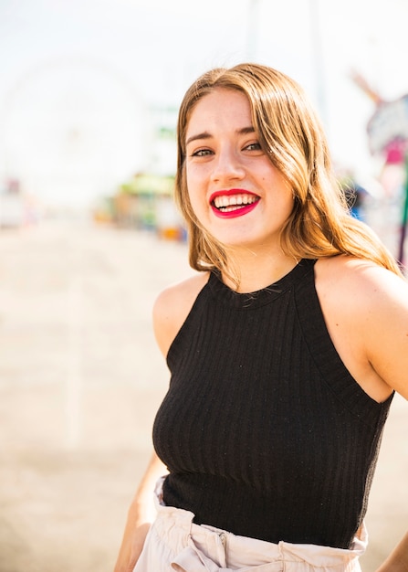 Portrait of smiling blonde young woman with red lipstick