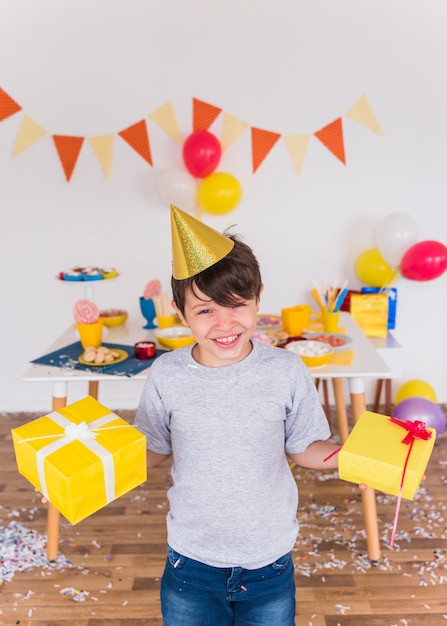 Portrait of a smiling boy holding birthday gift at home