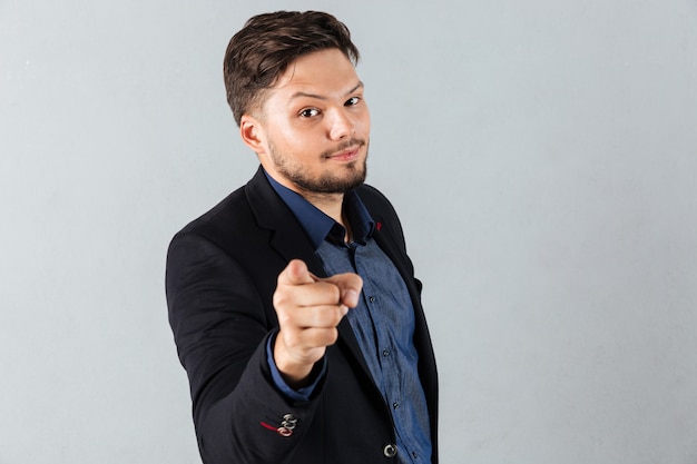 Portrait of a smiling businessman pointing finger