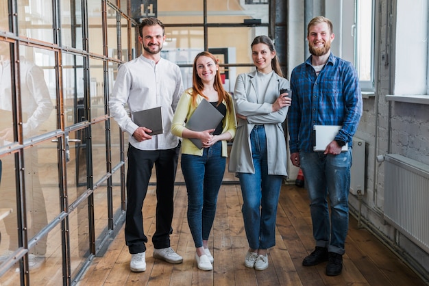 Free photo portrait of smiling businesspeople standing in office