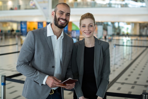 Portrait of smiling businesspeople with passport waiting in queue