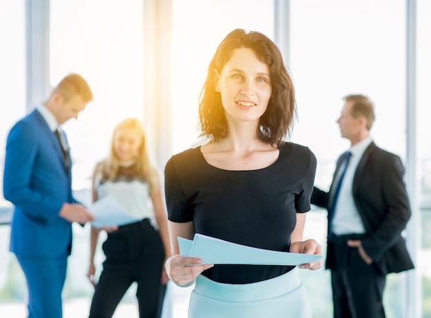 Free Photo portrait of a smiling businesswoman with documents