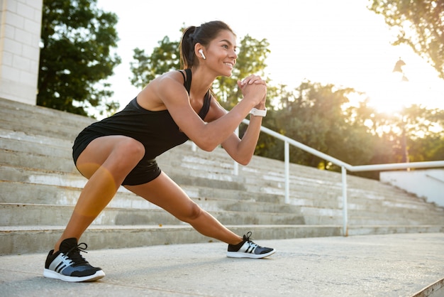 Portrait of a smiling fitness woman in earphones