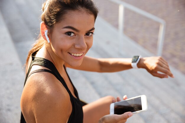 Portrait of a smiling fitness woman in earphones