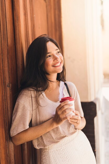 Portrait of a smiling girl holding disposable coffee cup