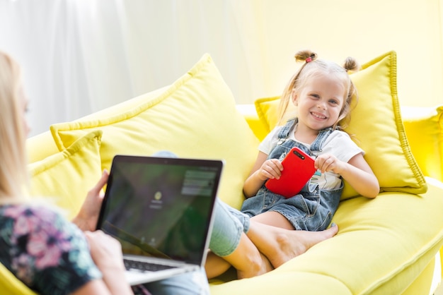 Free photo portrait of a smiling girl holding mobile phone