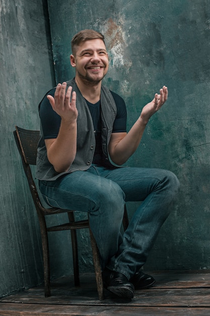 Free photo portrait of smiling happy man sitting on the chair