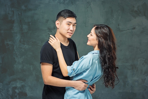 Portrait of smiling Korean couple on a gray