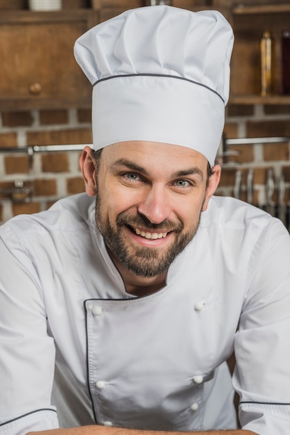 Portrait of smiling male cook wearing chef's hat