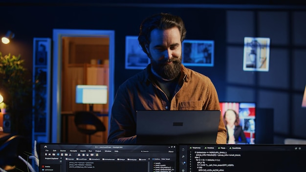 Portrait of smiling man doing IT support job from home standing in office