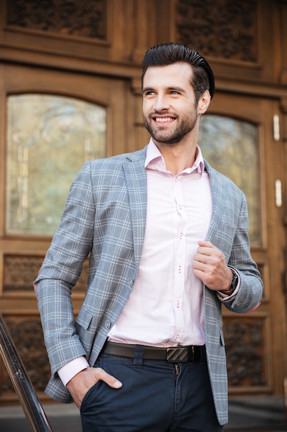 Portrait of a smiling man in jacket posing outdoors