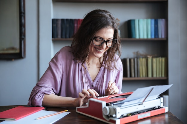 Portrait of a smiling mature authoress sitting at the table