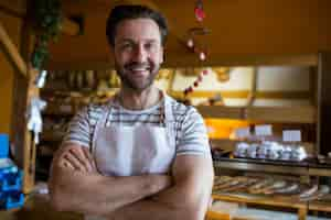 Free photo portrait of smiling owner standing in bakery shop