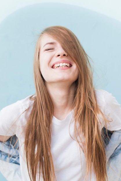 Portrait of smiling stylish young woman with eyes closed