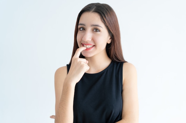 Portrait of smiling teenage Asian girl biting nail