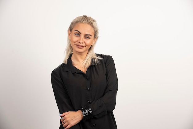 Portrait of smiling woman in black shirt posing on white background. High quality photo