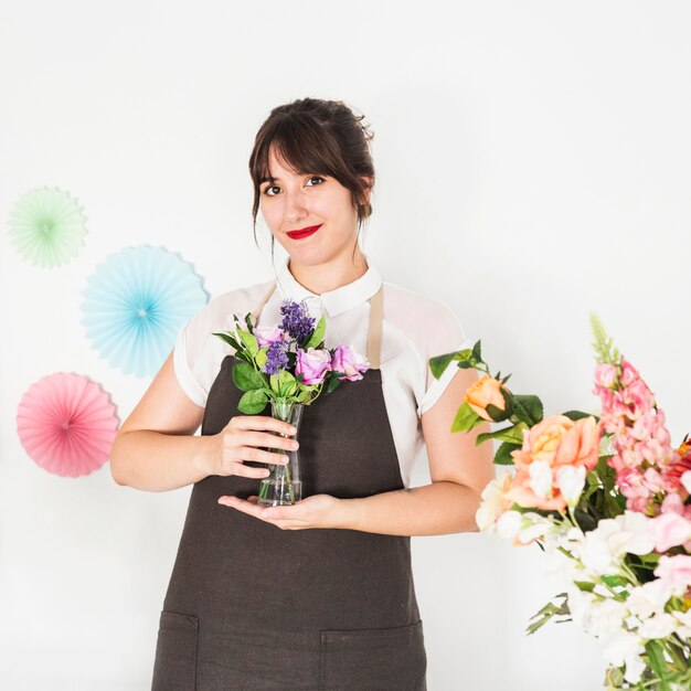 Portrait of a smiling woman holding flower vase