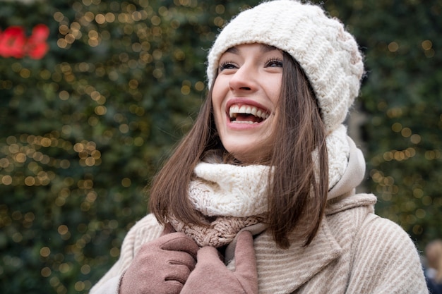 Free photo portrait of smiling woman outdoors with beanie