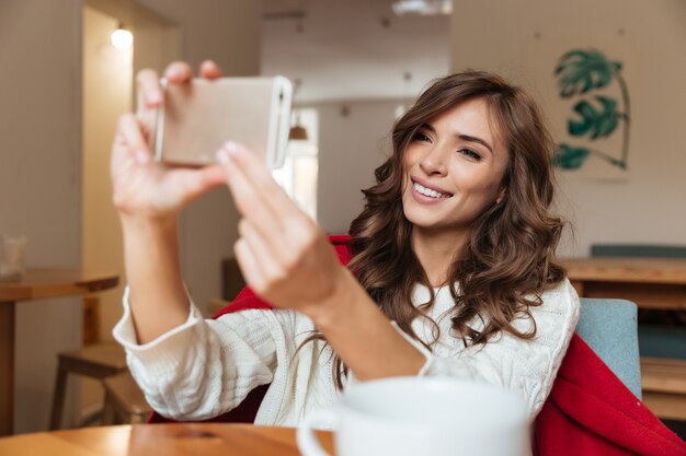 Portrait of a smiling woman taking a selfie