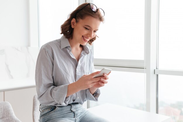 Portrait of a smiling woman texting on mobile phone