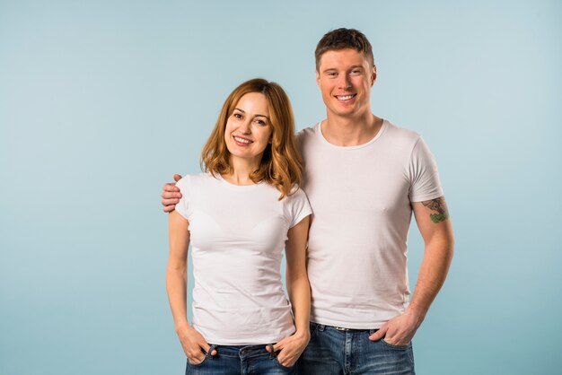 Portrait of a smiling young couple against blue background