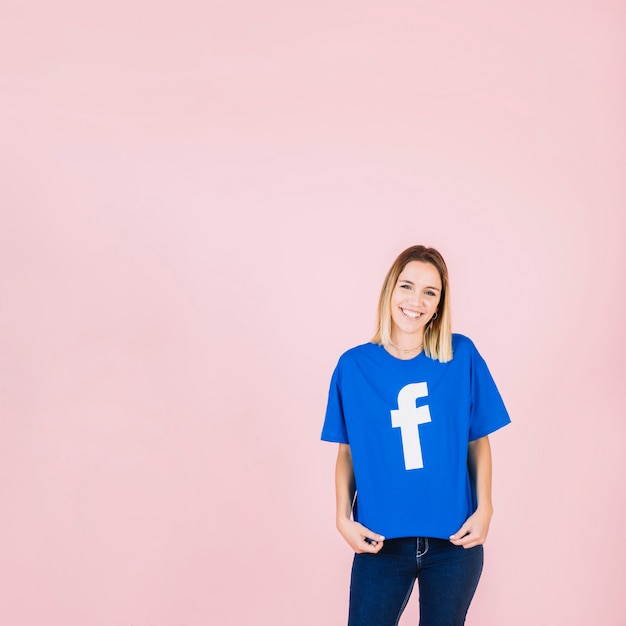 Free Photo portrait of a smiling young friend with blue facebook t-shirt