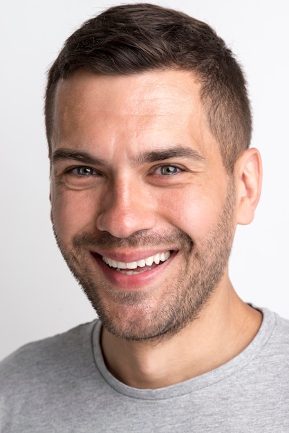 Portrait of smiling young man in grey t-shirt looking at camera