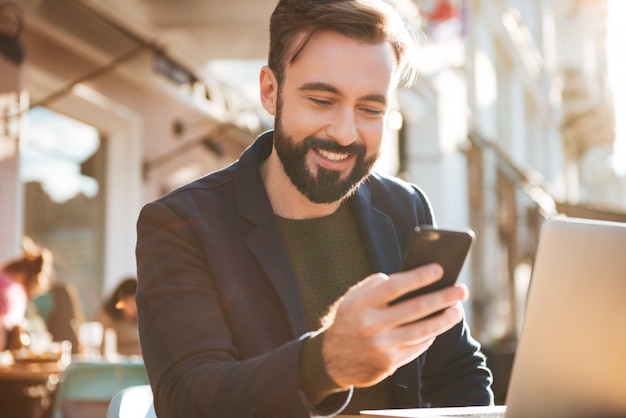 Portrait of a smiling young man holding mobile phone