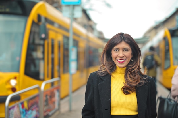 Free Photo portrait of smiling young woman. in the background two trams