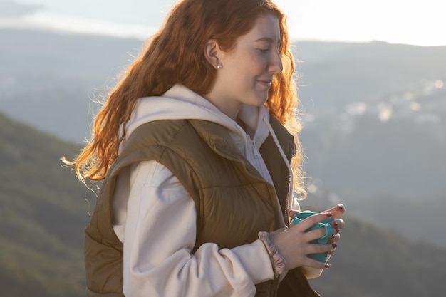 Portrait of smiling young woman drinking tea outdoors