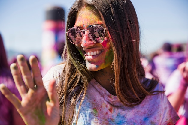 Portrait of a smiling young woman enjoying in the holi