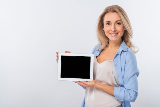 Portrait of a smiling young woman showing digital tablet against white background