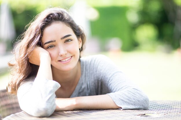 Portrait of smiling young woman sitting at table