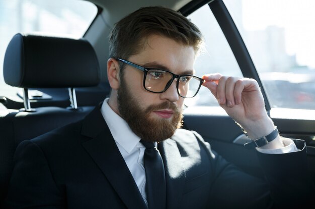 Portrait of a srious young man wearing suit and eyeglasses