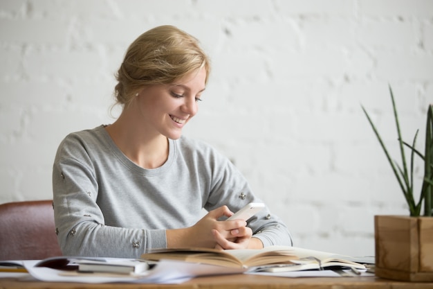 Portrait of a student girl at the desk with phone