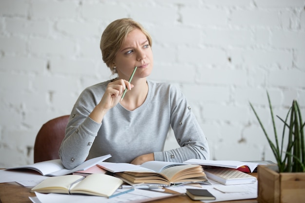 Portrait of a student woman at the desk, frowned