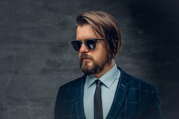 Free photo portrait of stylish bearded hipster male dressed in a jacket, bow tie and sunglasses.