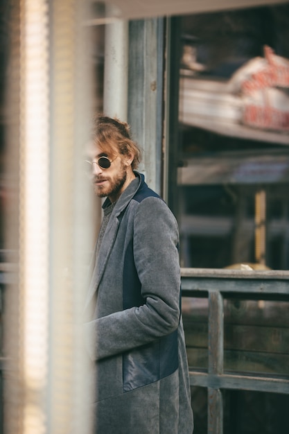 Free Photo portrait of a stylish bearded man dressed in coat walking