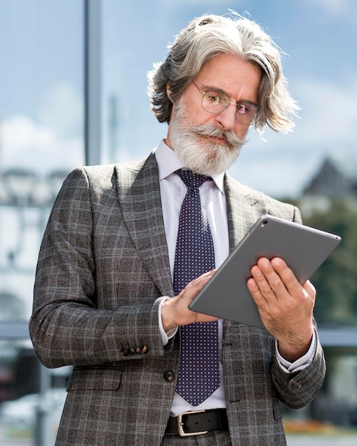 Free photo portrait of stylish bearded man holding tablet