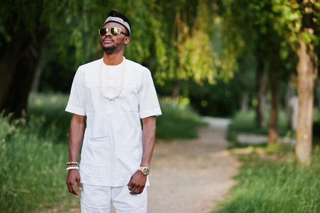 Portrait of stylish and rich black african american man on white clothes sunglasses and hat