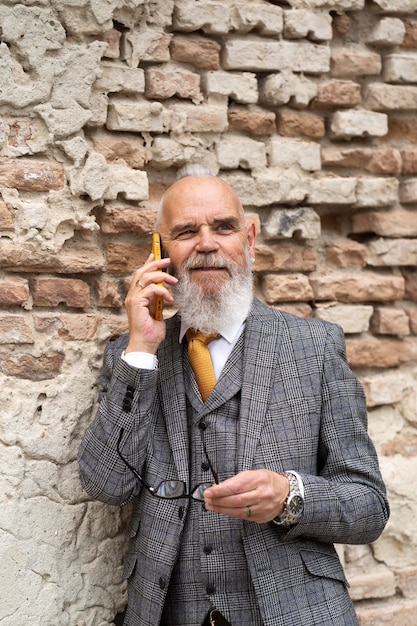 Free Photo portrait of stylish senior man on his phone