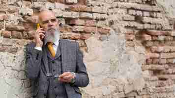 Free photo portrait of stylish senior man on his phone