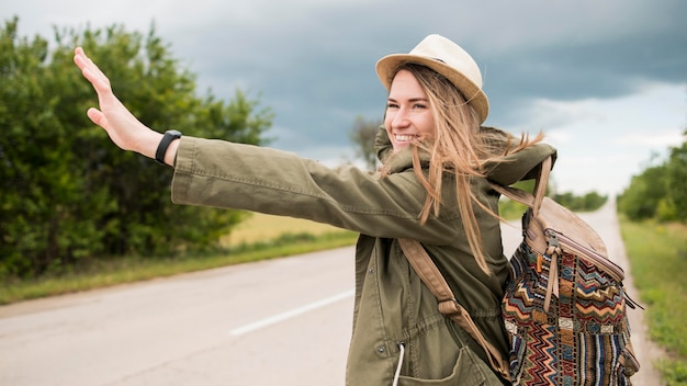 Free Photo portrait of stylish traveller hitchhiking