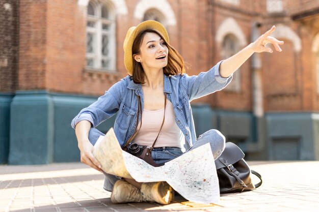 Portrait of stylish traveller with hat and map