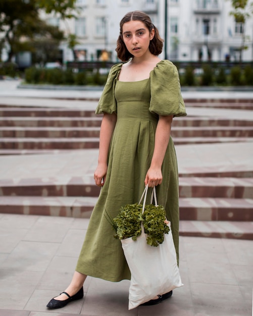 Free photo portrait of stylish woman carrying groceries bag