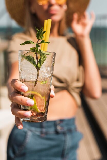 Portrait of stylish young woman enjoying summer cocktail