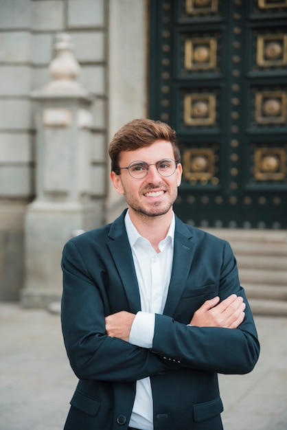 Portrait of successful young businessman with his arms crossed looking at camera