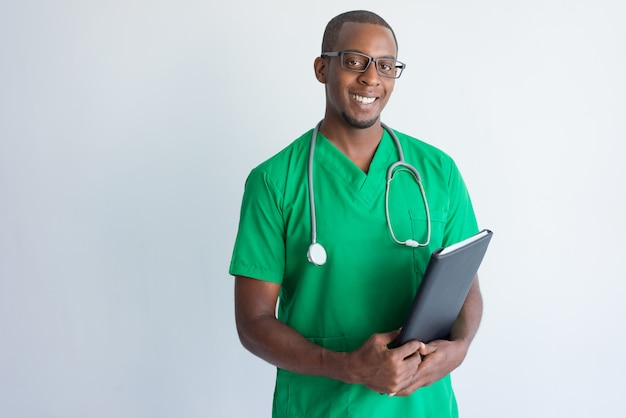 Portrait of successful young doctor with folder and stethoscope. 