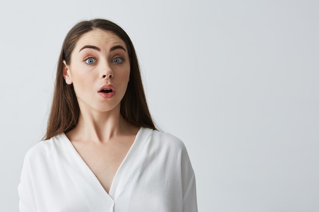 Portrait of surprised young beautiful businesswoman with opened mouth .